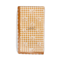 Stack of fall gingham paper dinner napkins showing the orange-cream check pattern and wavy edge, front view.