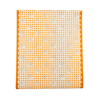 Fall gingham paper table runner in orange and cream block-print checks with orange scalloped edges, overhead flat-lay view on gray background.