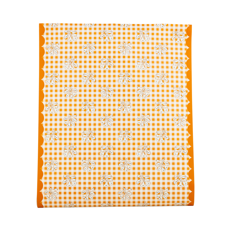 Fall gingham paper table runner in orange and cream block-print checks with orange scalloped edges, overhead flat-lay view on gray background.