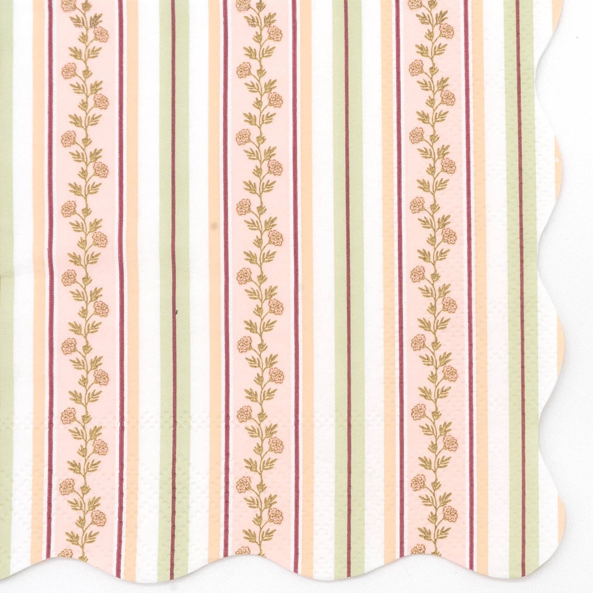 Close-up of a fall harvest floral cocktail napkin showing vertical stripes in cream, blush pink, peach, sage green, and burgundy with climbing gold floral vines and a wavy scalloped edge.