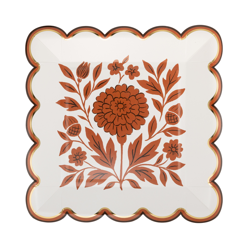 Cream scalloped paper plate with an orange marigold floral, brown edge, and gold foil accents, front view.