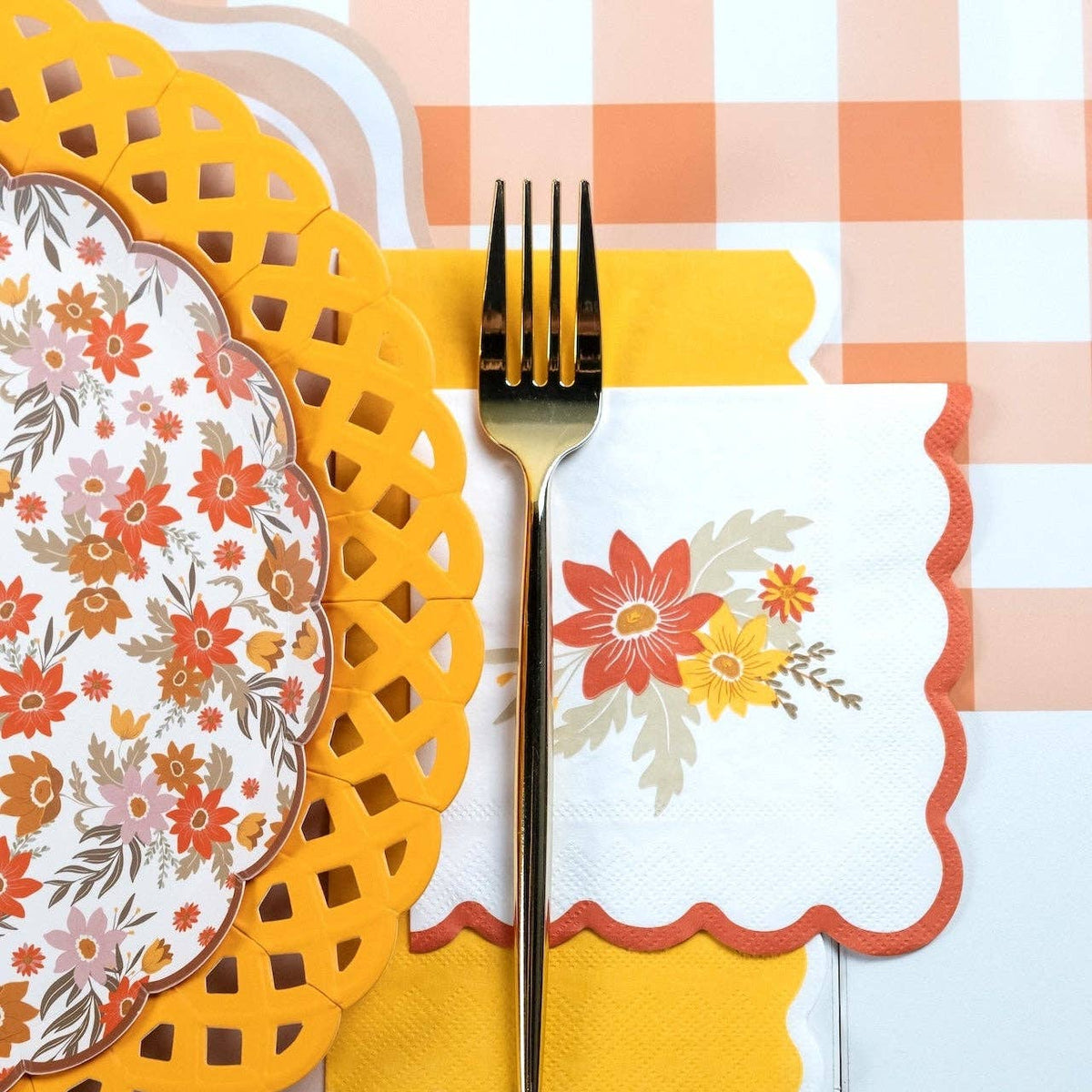 Fall place setting close-up showing the yellow basketweave charger under a floral plate with a striped runner.