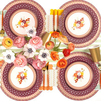 Overhead fall table with multiple burgundy basketweave plates, floral salad plates, gold flatware, and autumn florals.