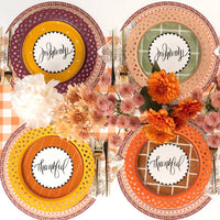 Overhead fall table with burgundy plates, floral salad plates, gold flatware, and a fall floral centerpiece.