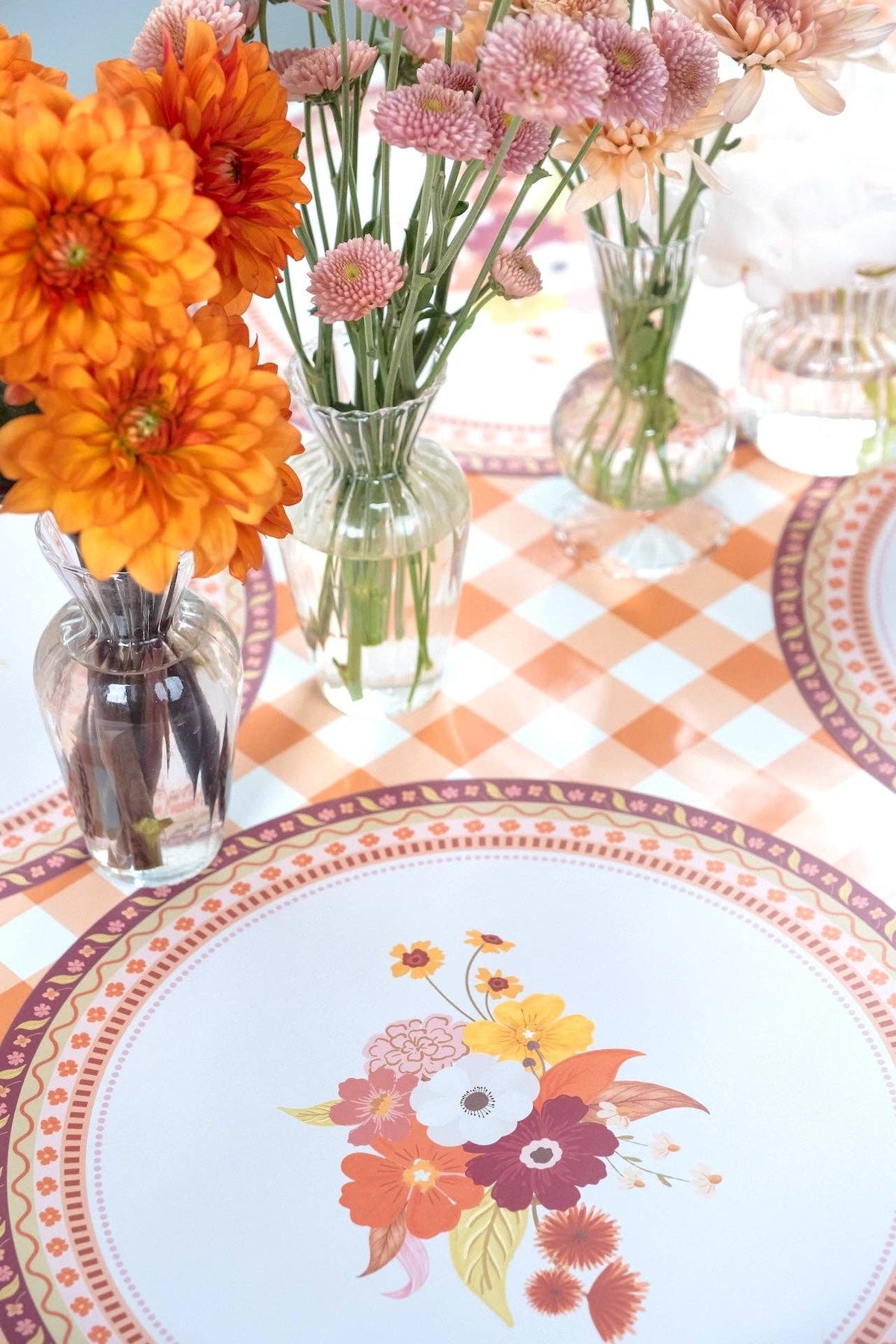 Overhead fall table showing the floral placemats layered with floral plates, fresh flowers, and a gingham runner.