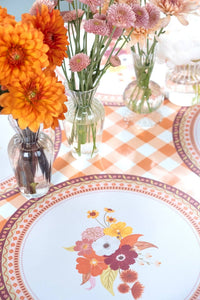 Overhead fall table showing the floral placemats layered with floral plates, fresh flowers, and a gingham runner.