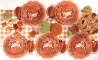 Overhead fall table showing turkey shaped plates with floral plates, orange chargers, cookies, and autumn florals.