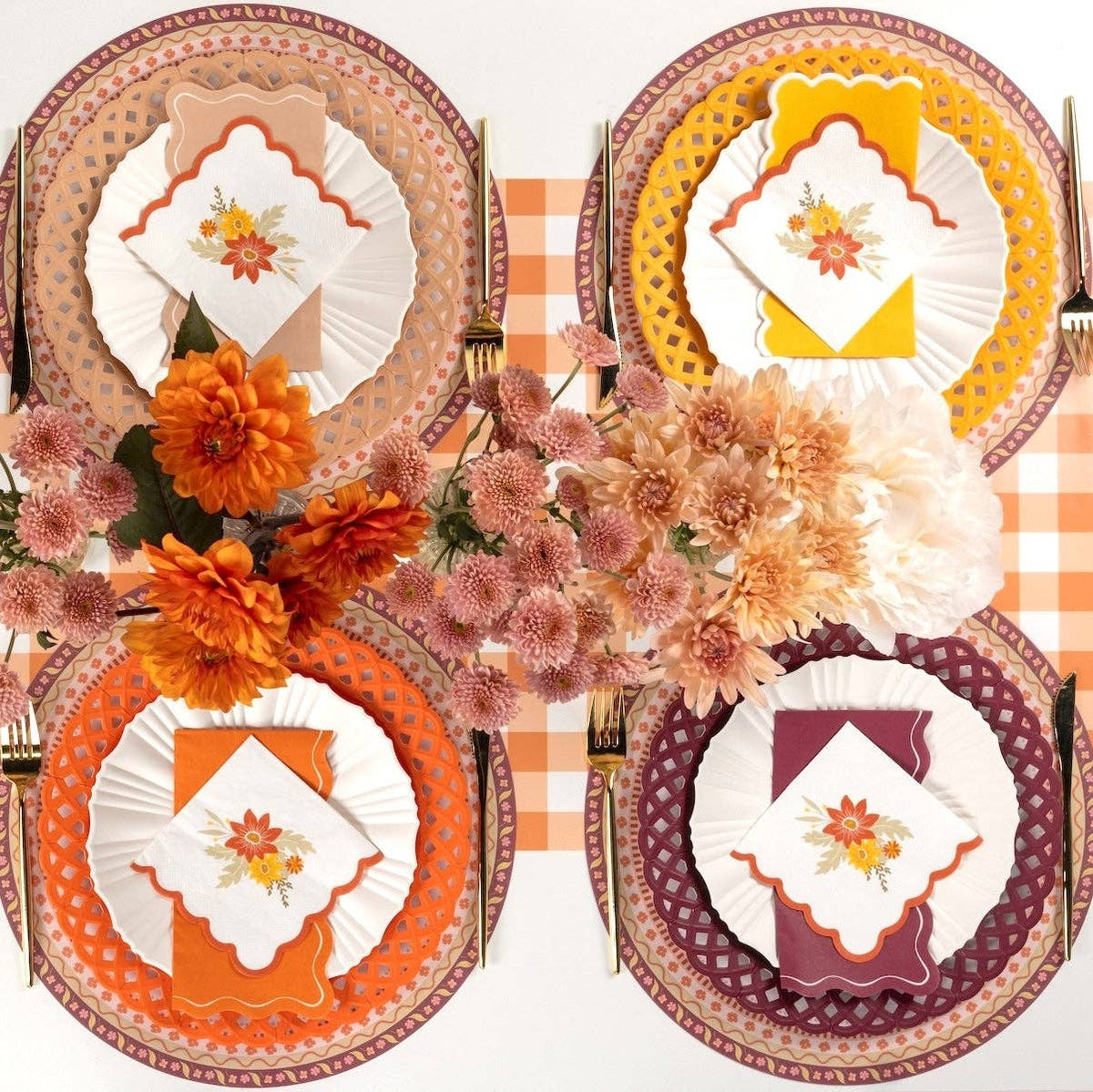 Overhead fall tablescape showing burgundy napkins with turkey and floral plates, burgundy chargers, and autumn florals on a gingham runner.