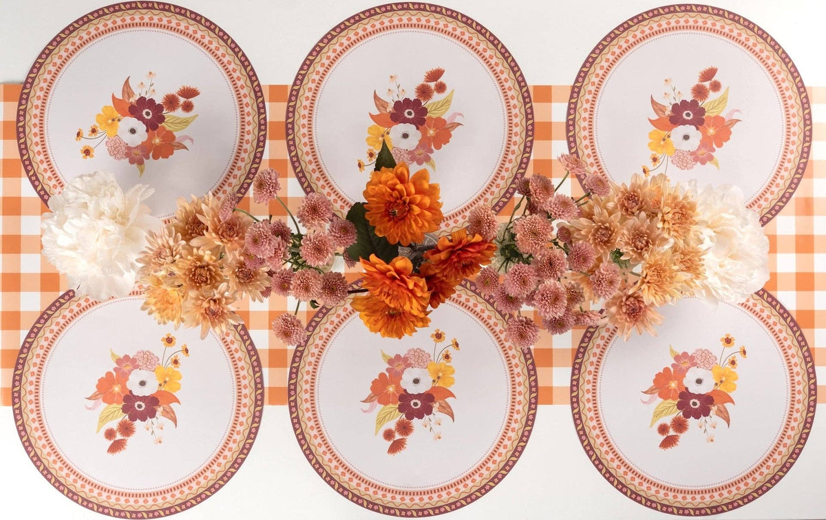 Overhead fall tablescape showing the floral placemats with floral plates, an autumn floral centerpiece, and gold flatware.