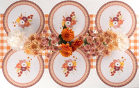 Overhead fall tablescape showing the floral placemats with floral plates, an autumn floral centerpiece, and gold flatware.