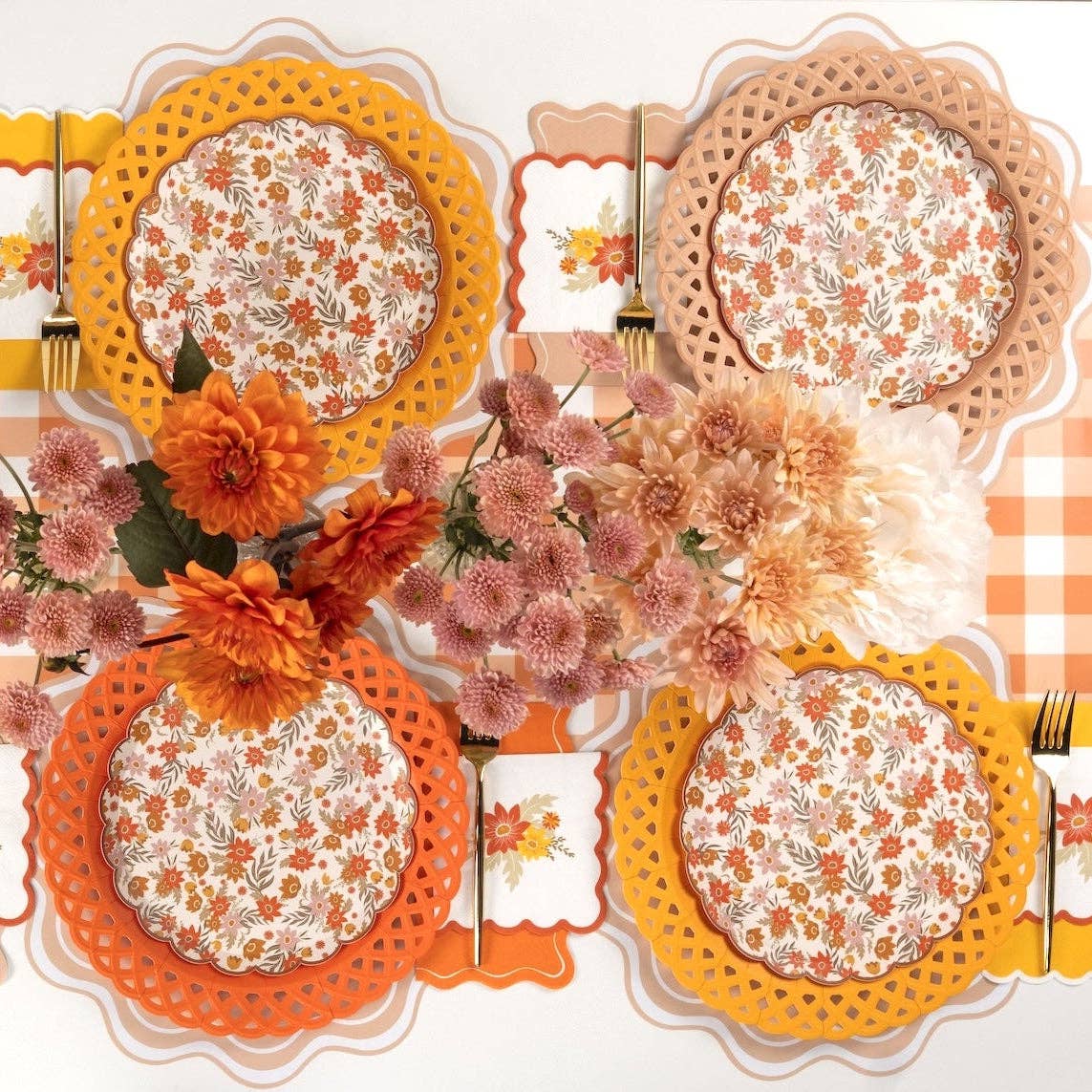 Overhead fall tablescape showing yellow basketweave plates layered with floral plates, orange florals, and gold flatware on a gingham runner.