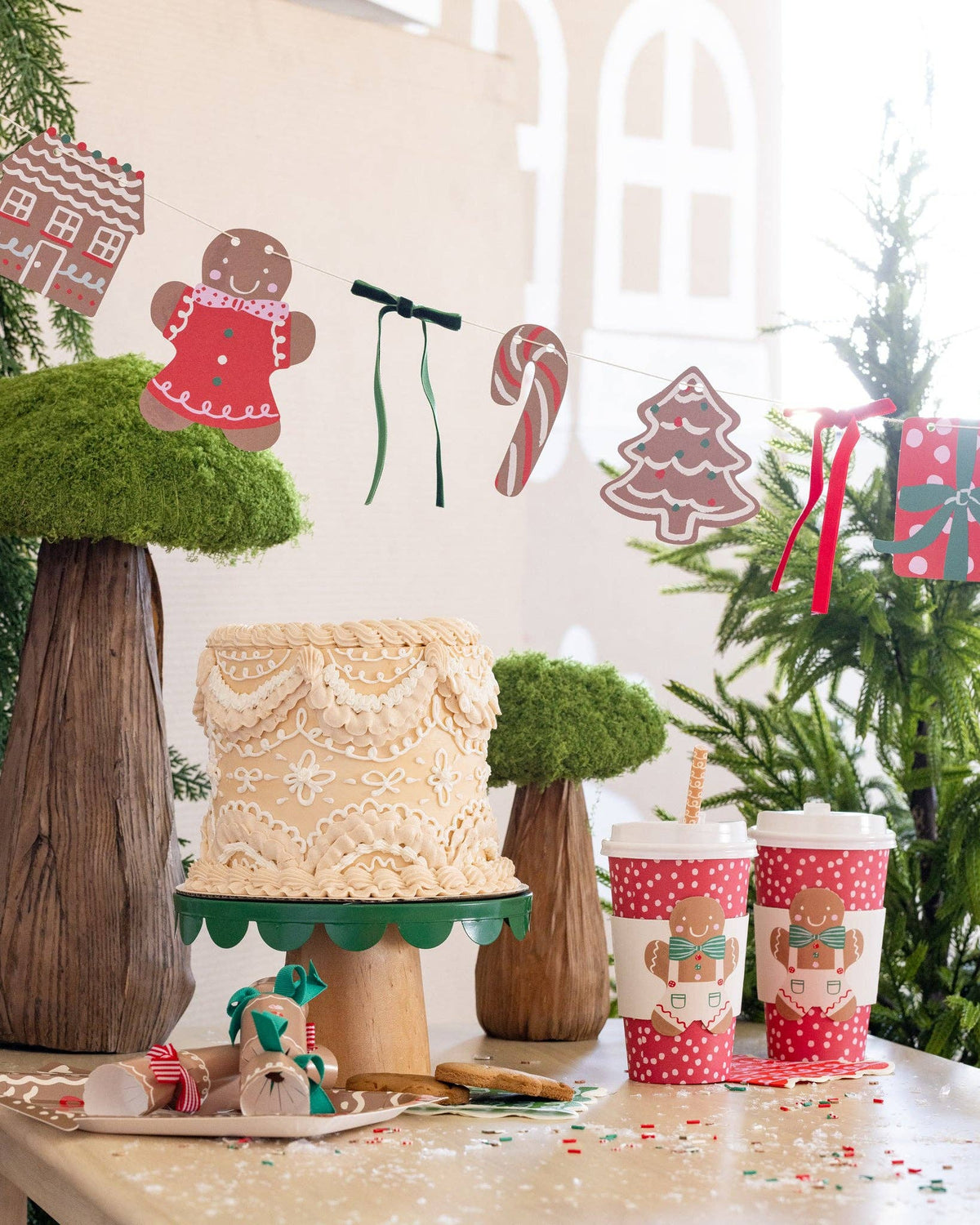 Close-up of Gingerbread Banner hung above a dessert table with cake and cups.
