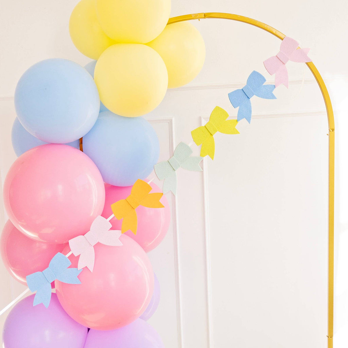 A 5-foot pastel felt bow garland against a white background, perfect for birthday parties or children's room decor.