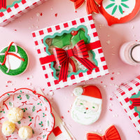 Flat lay showing the paper dessert plates and coordinating gingham cookie boxes on a pink background.