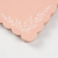 Close-up of scalloped edge and floral detail on pink napkin