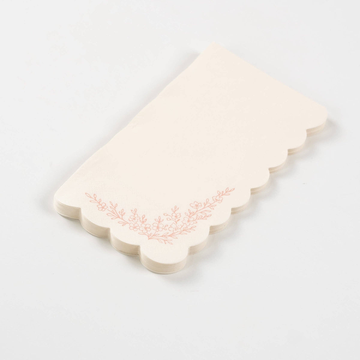 Fanned stack of pink scalloped guest towels on a white surface