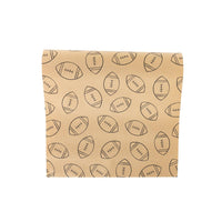 Kraft paper table runner printed with hand-drawn black footballs, partially unrolled