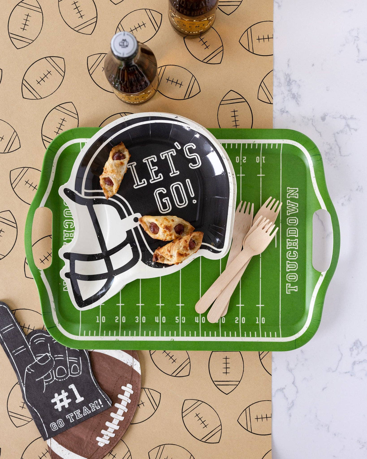 Football table runner under a green field tray with a helmet plate, snacks, and wooden forks