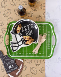 Football table runner under a green field tray with a helmet plate, snacks, and wooden forks
