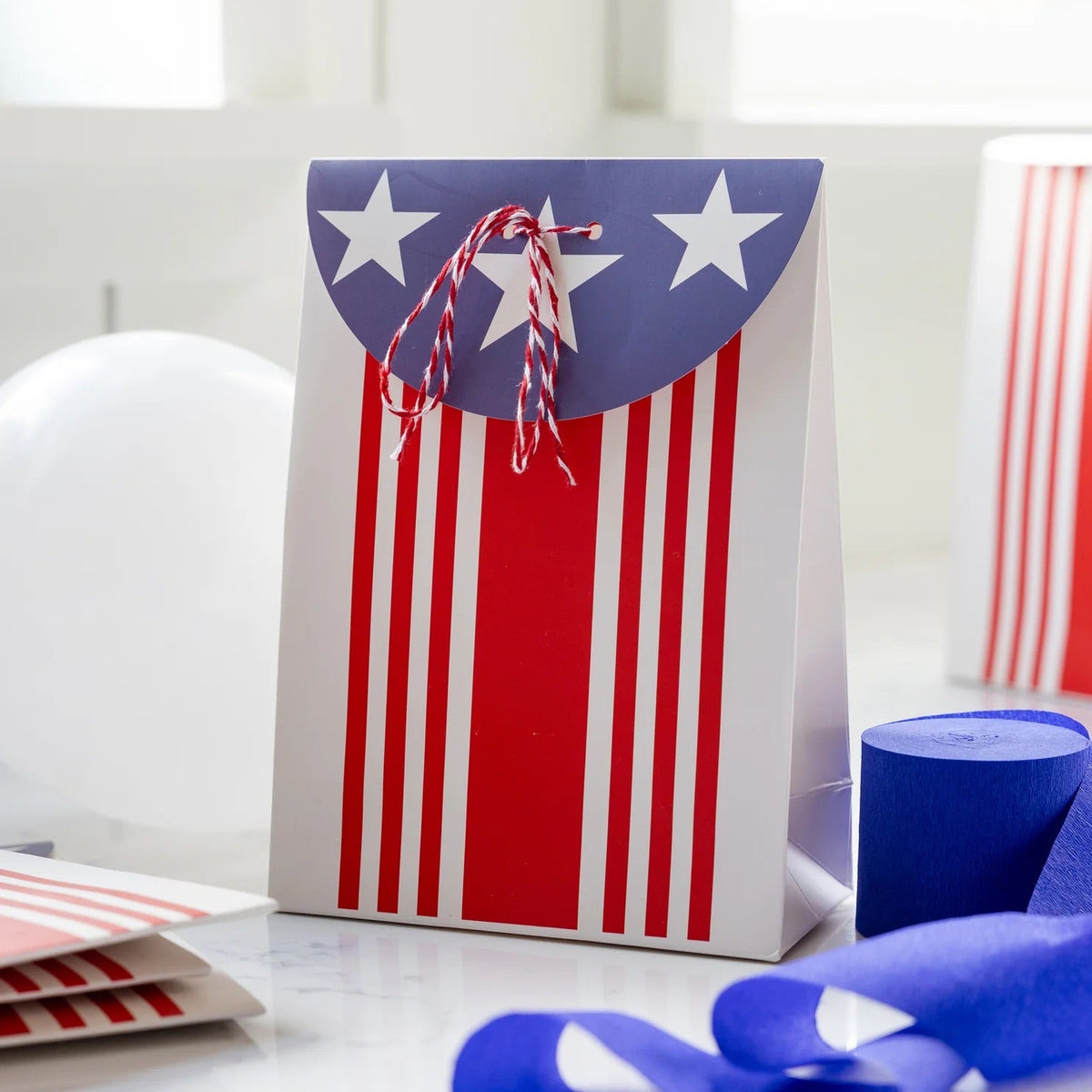 Close-up of a patriotic treat bag tied with red and white baker’s twine, great for filling with candy or small toys.