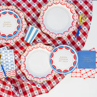 Guests enjoying burgers and sides on Happy 4th of July Plates at a party.