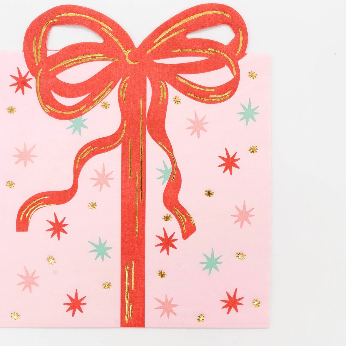Front-facing studio shot of the pink square paper napkin displaying the full vintage wrapped present illustration with a prominent red bow.