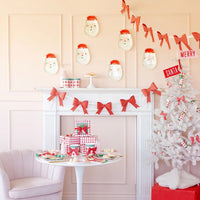 Full room display of a holiday setting featuring the Christmas party plates on a table and Santa plate cutouts hung on the wall.