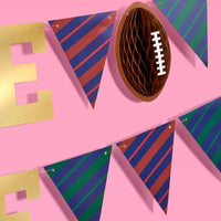 Side view of brown accordion football decoration attached to banner string