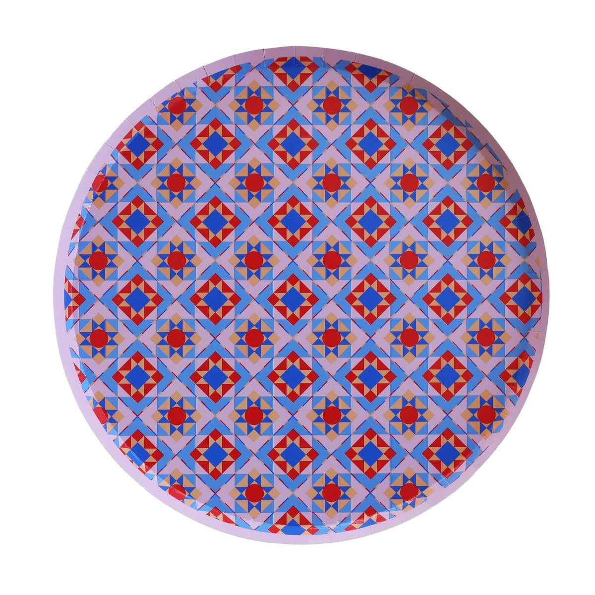 Round geometric holiday paper plate with an all-over folk-art medallion pattern in blue, red, and pink, overhead view on white background.