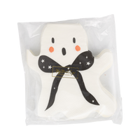Close-up front view stack of a ghost-shaped napkin showing the cream body with pink and black accents inside a clear packaging. 