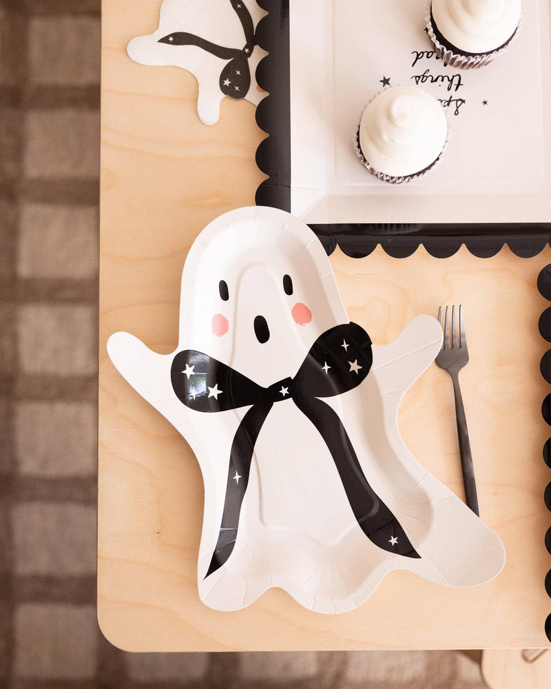Close-up of the black and pink detail on the cream ghost plate styled with other Halloween decorations.