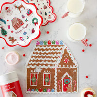 Gingerbread house jigsaw puzzle on a marble counter with milk and frosted cookies; Merry + Bright plates shown separately, not included