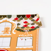 Foil-edged scallop roof with holly garland—perfect for gingerbread house themes