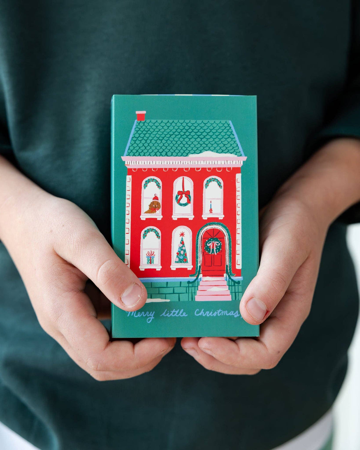 Child holding gingerbread man treat box in green and blue stripes