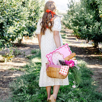 Girl carrying outdoor picnic basket styled with gingham napkins