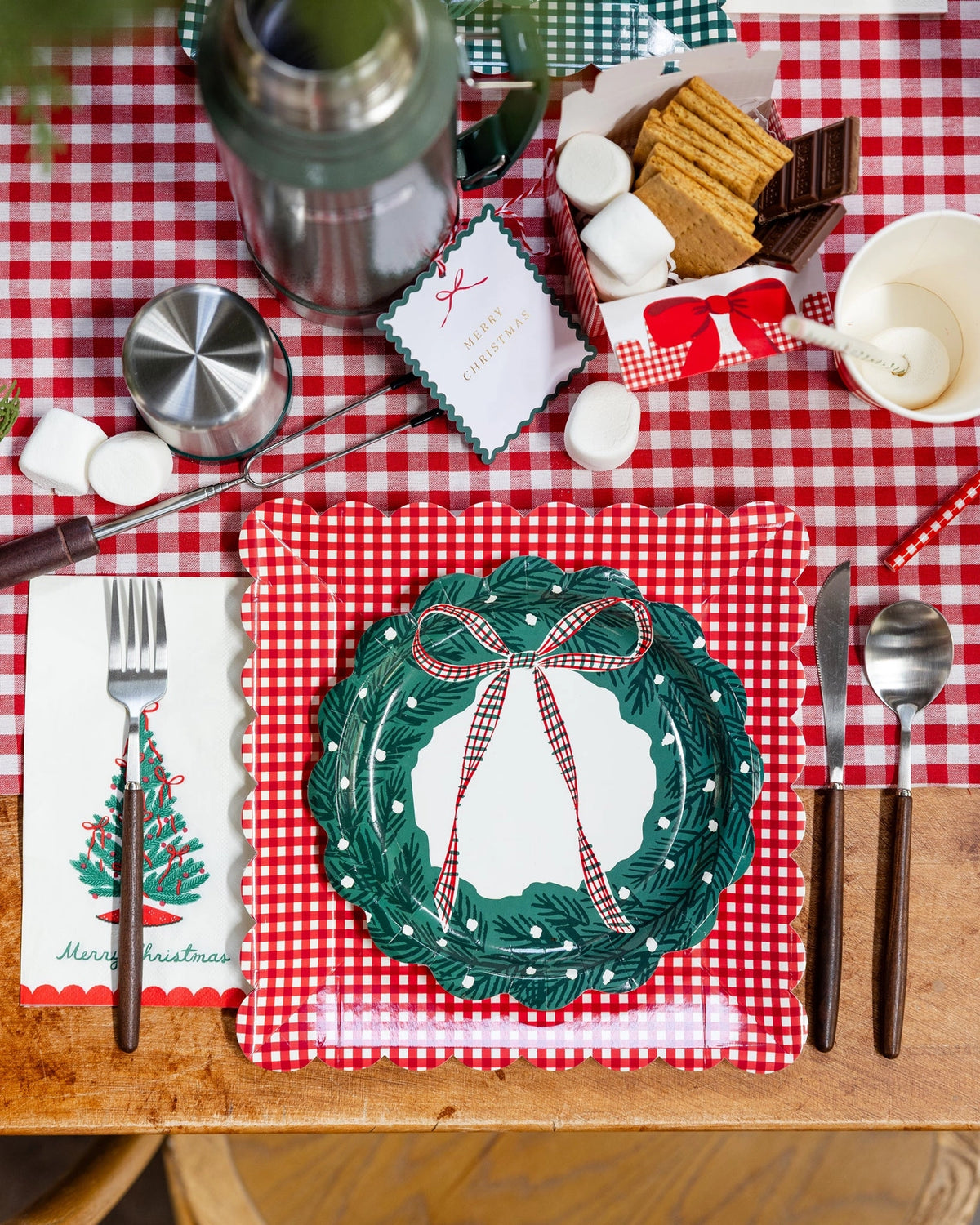 Gingham table with the plates, a wreath plate, and s'mores on a plaid runner.