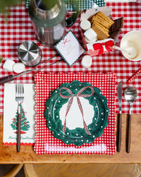 Gingham table with the plates, a wreath plate, and s'mores on a plaid runner.
