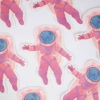Scattered pink girl astronaut die-cut paper napkins showing the spacewalk pose