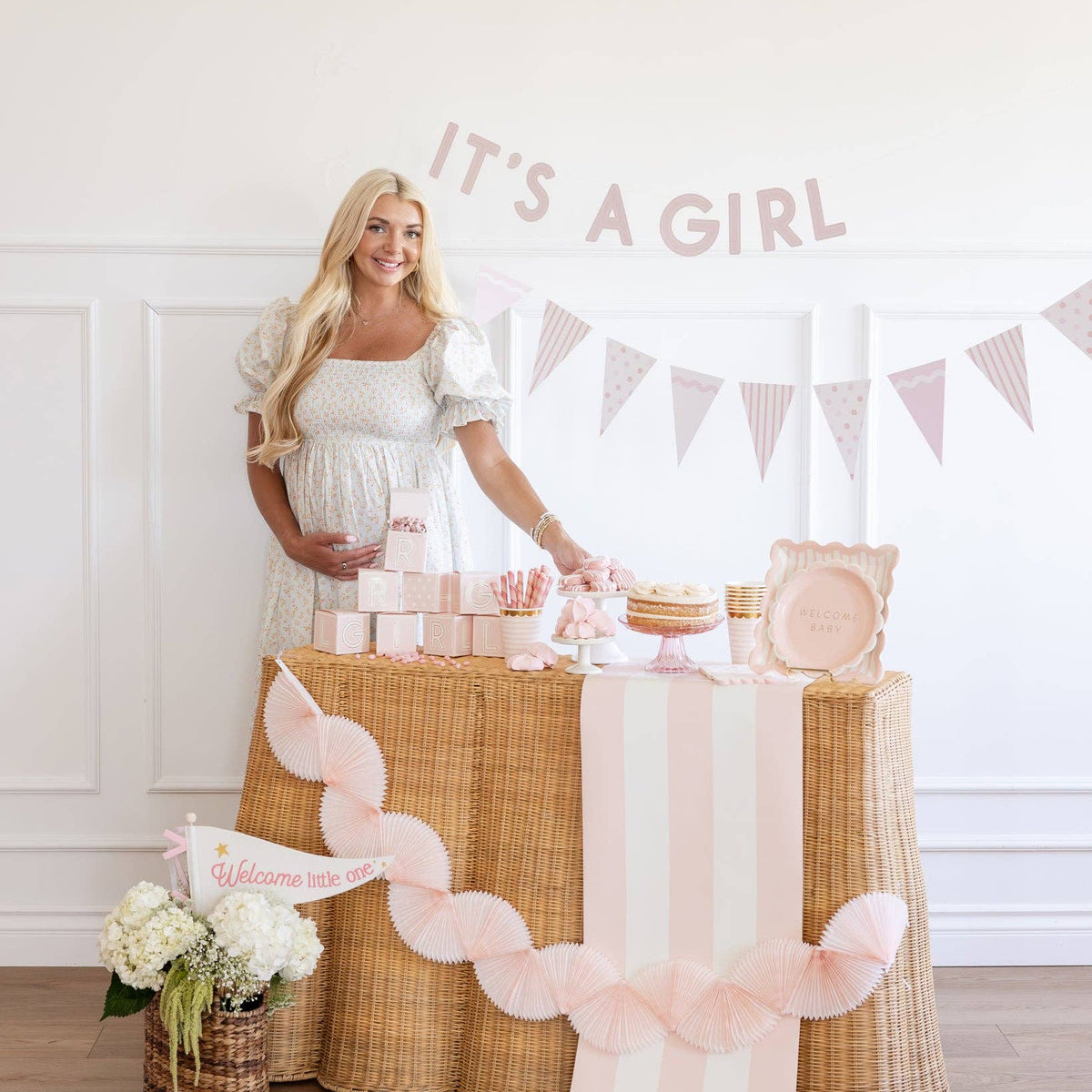 Baby shower table with pink striped runner and girl decor