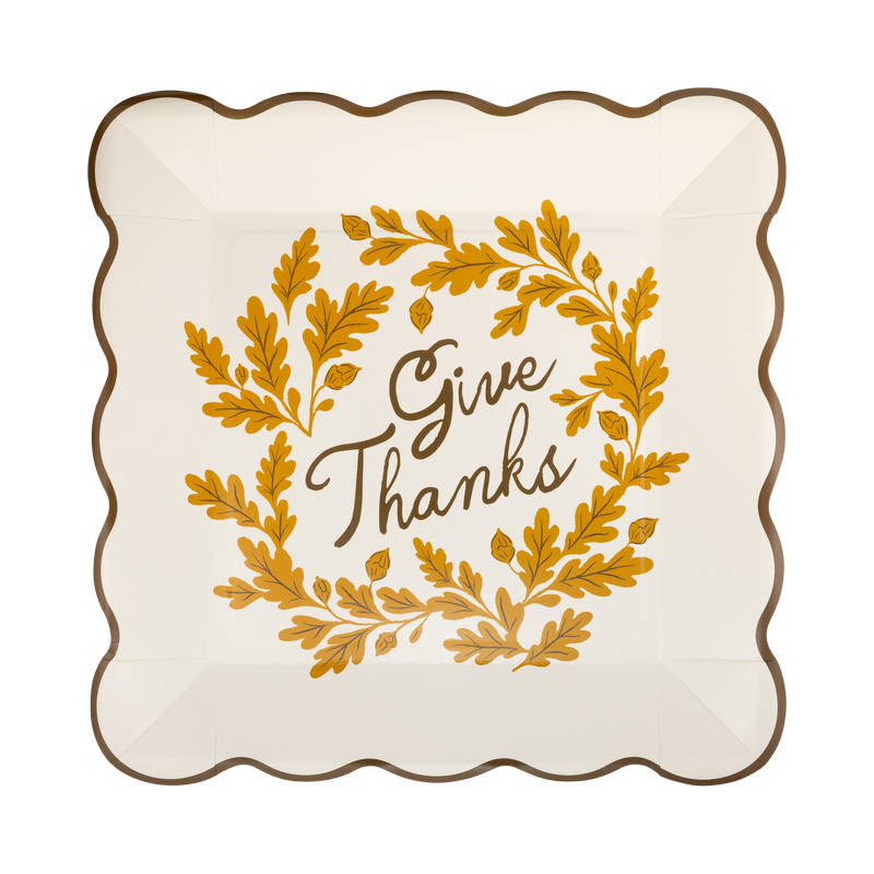 Cream paper plate with a brown "Give Thanks" wordmark and a wavy edge, front view.