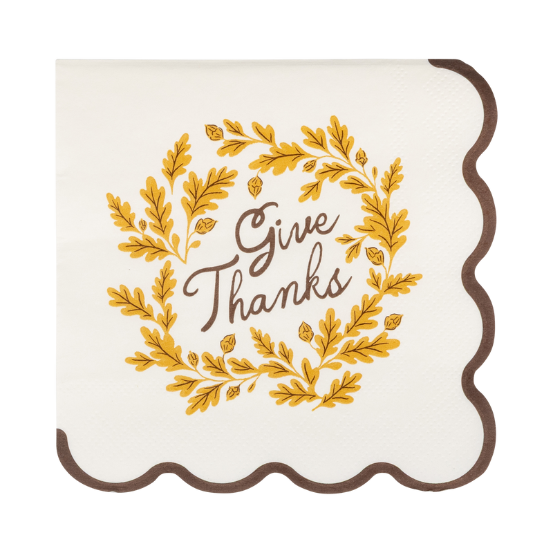 Cream cocktail napkin with "Give Thanks" text, brown and yellow accents, and a wavy brown edge, front view.