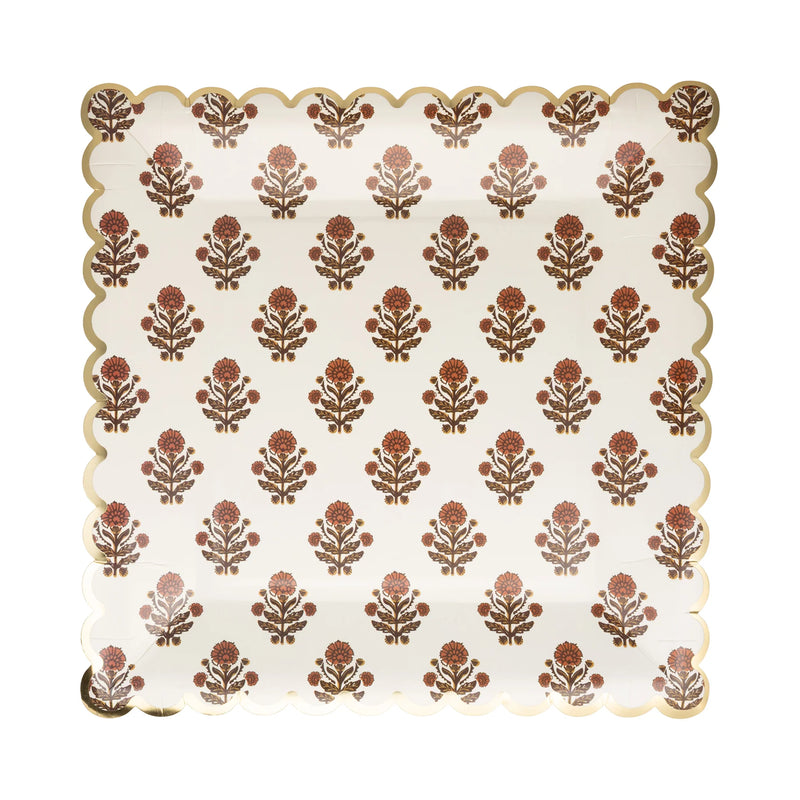 Close-up of gold trim and block-print floral artwork on paper plate.