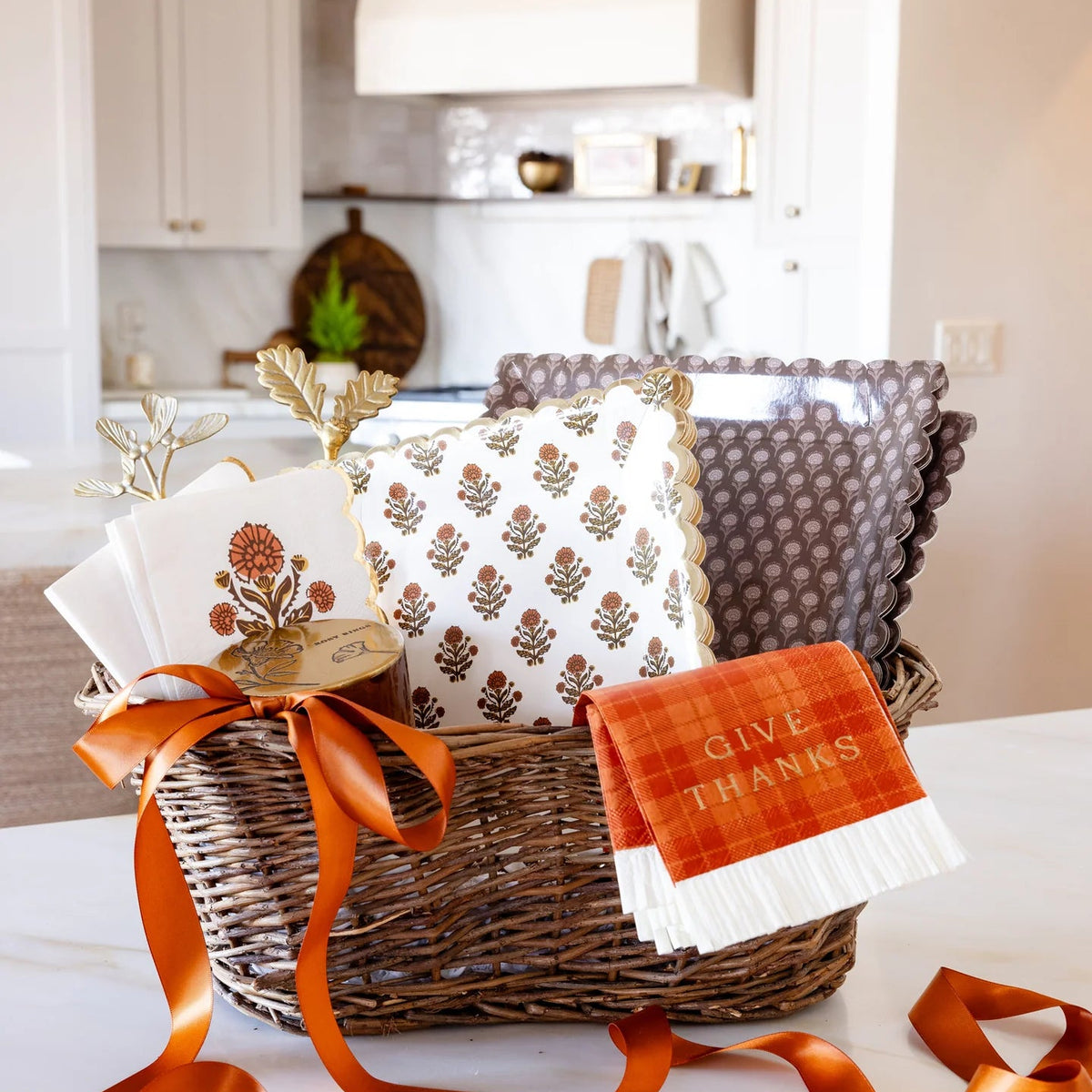 Gift basket filled with coordinating fall tableware and floral napkins.