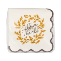 Decorative paper napkin with 'Give Thanks' text and gold leaf design on a clear cover.