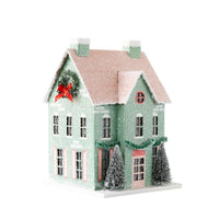 Angled view of a mint glitter house showing the wreath gable and side windows with pink shutters