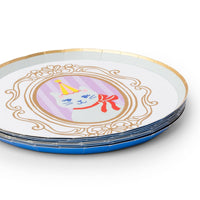 Close up angled view of a stack of small round paper dessert plates highlighting the metallic gold foil cameo frame and raised rim.