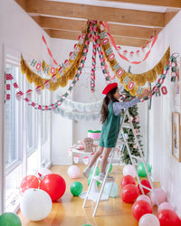 Party room with gold fringe banners, streamers, and balloons.