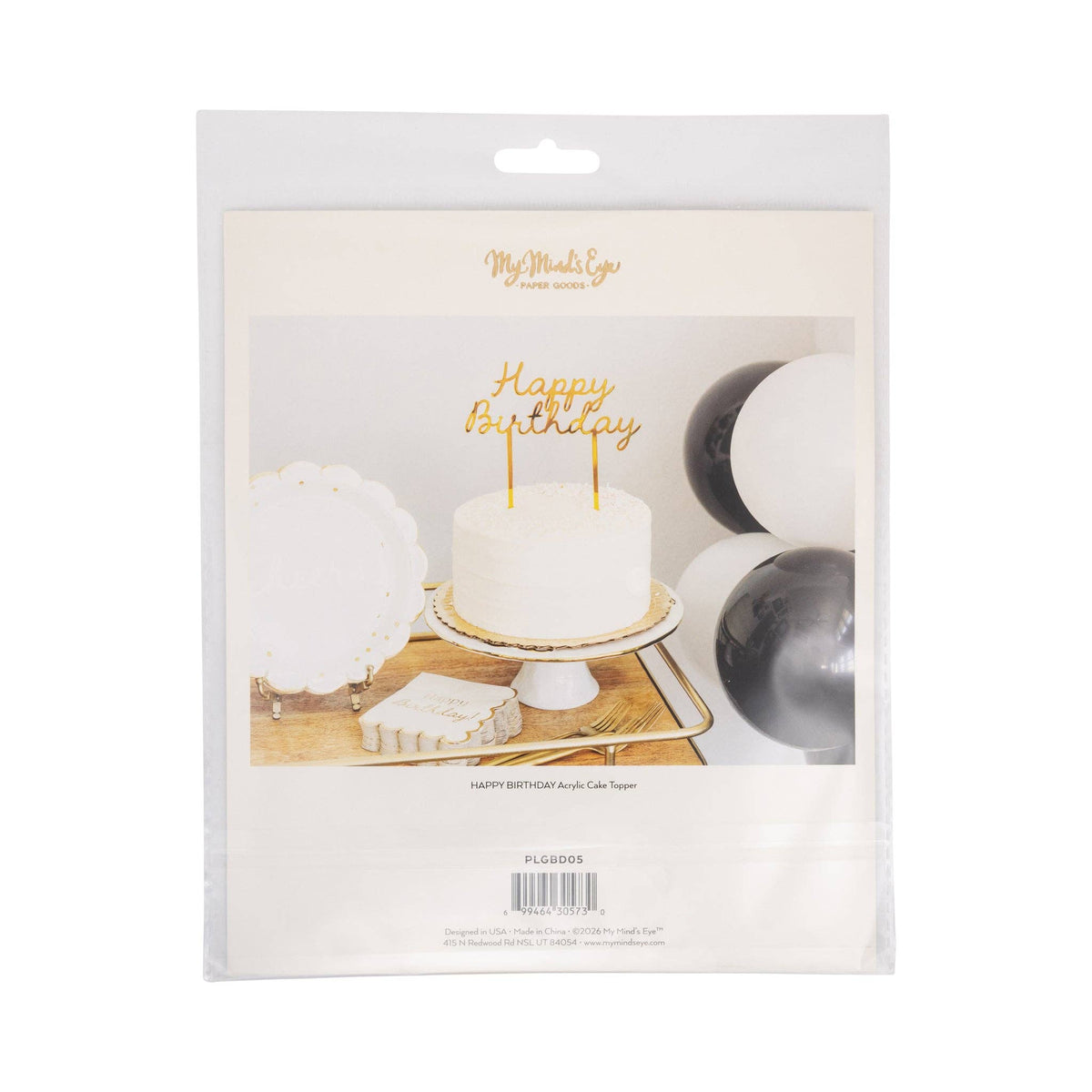 Back of My Mind's Eye gold Happy Birthday acrylic cake topper packaging showing mirror gold topper on white buttercream cake with black and white balloon garland and gold bar cart