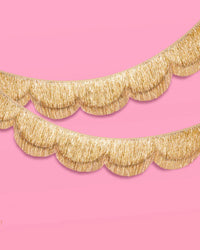 Two gold scalloped fringe banners stacked on pink background showing double-layer construction