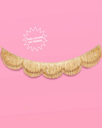 Gold scalloped fringe banner on pink background with callout reading "two layers of fringe"